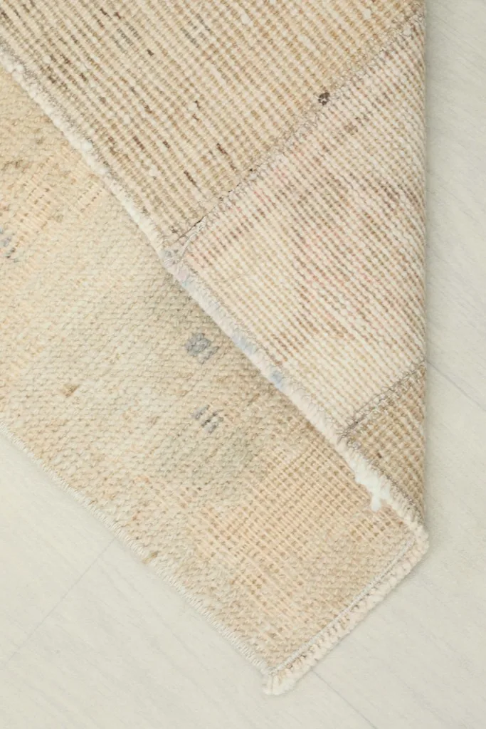 View of the back of the hand-knotted wool pile on cotton foundation, folded over.