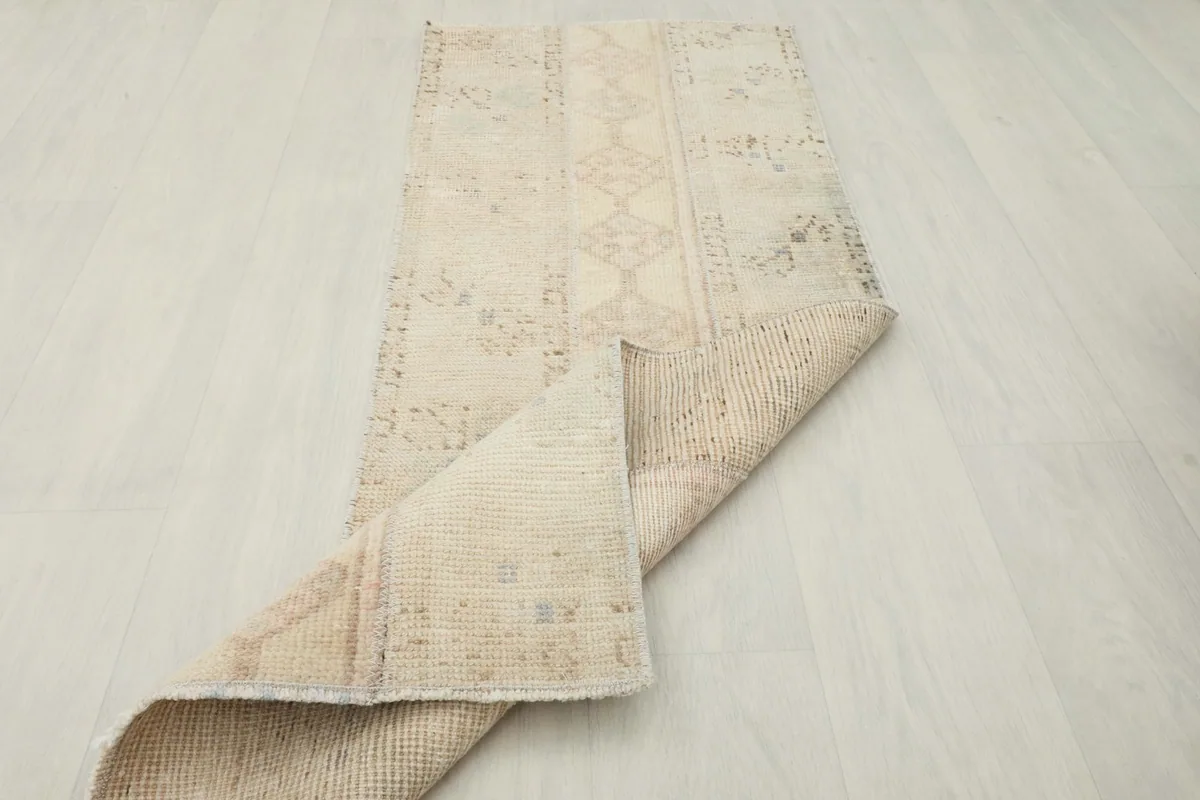 The cream runner partially folded, showing its flexibility and the reverse side.