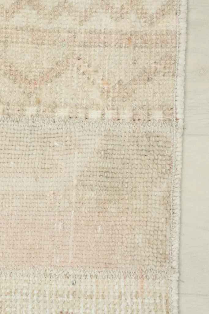 Close-up of the rug's edge, showing the finished border and the texture of the wool pile.