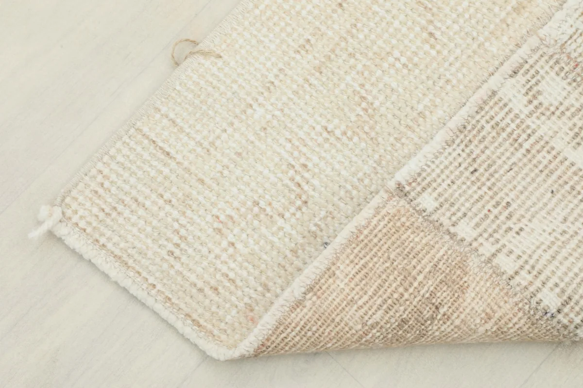 View of the back of the rug, revealing the cotton foundation and the hand-knotted structure.
