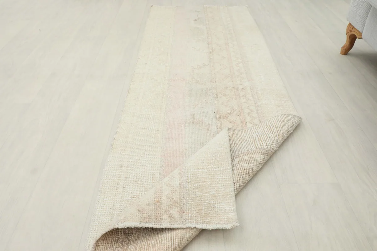 The runner rug with one end folded back, showing both the pile and the foundation.