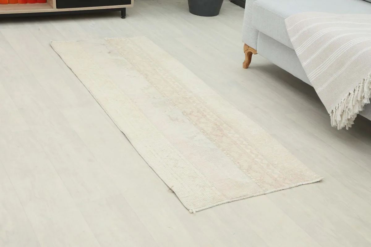 Overhead view of the beige runner rug, highlighting its elongated shape and subtle pattern.