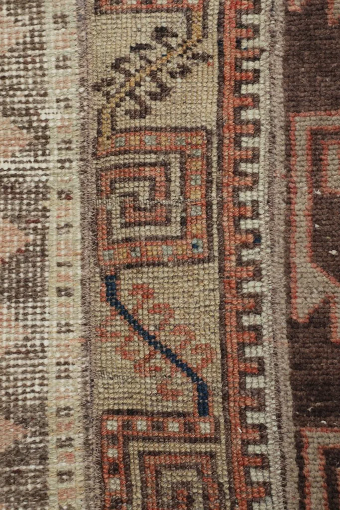 Detailed view of the intricate hand-knotted wool pile and color variations, including navy accents.