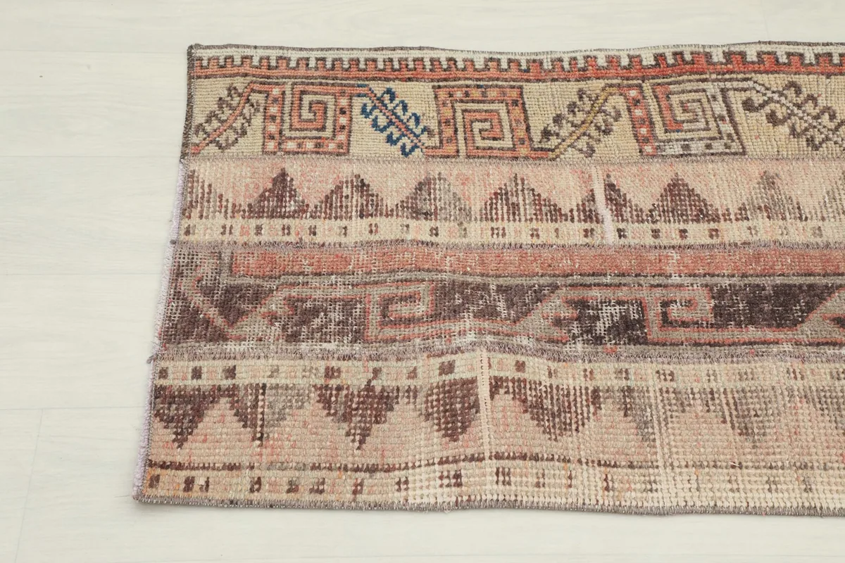 Close-up detail of the upper left section of the rug, revealing the varied textures and patterns.