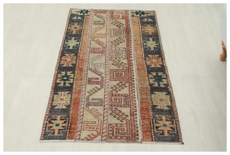 Full top view of the 2x4 beige, rust, and charcoal tribal Anatolian rug on a white background