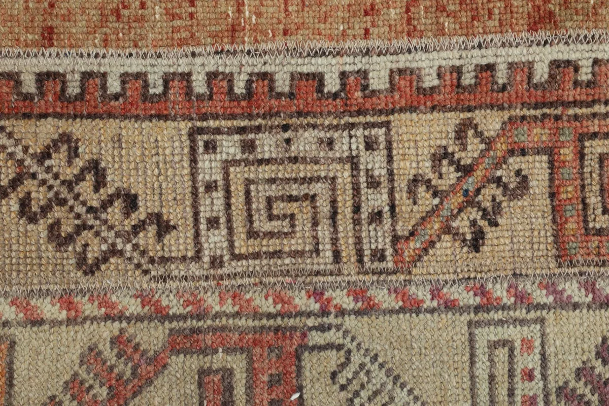 Detailed view of the intricate geometric motifs and the subtle color shifts in the wool pile