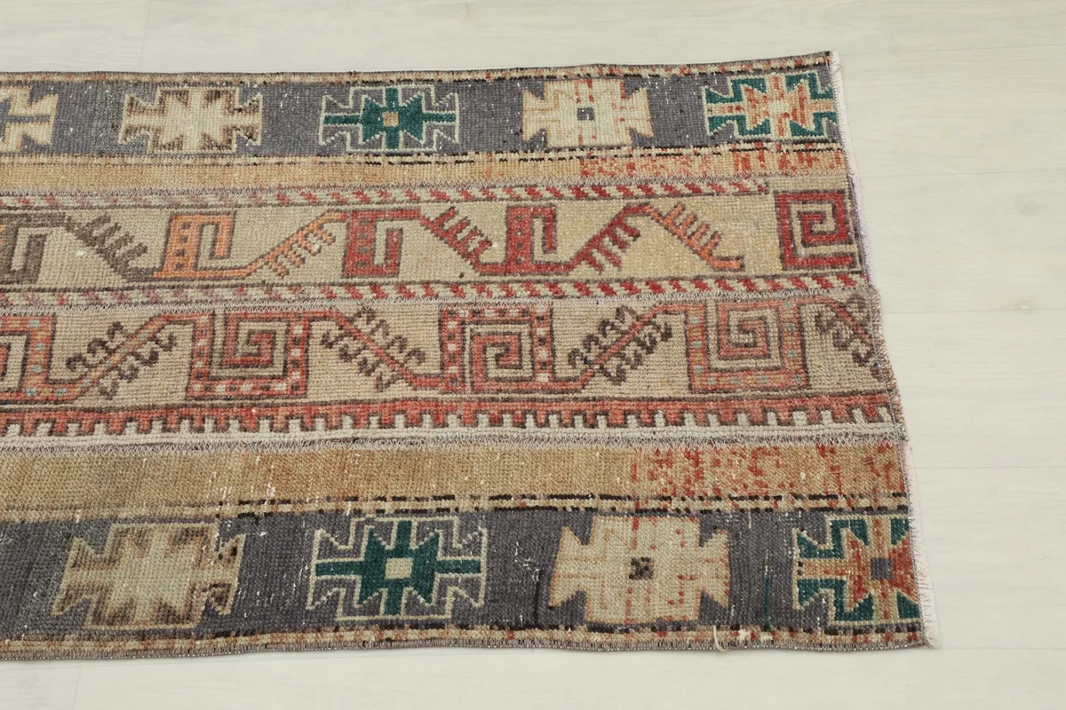 Close-up detail of the geometric patterns and colors on one end of the rug