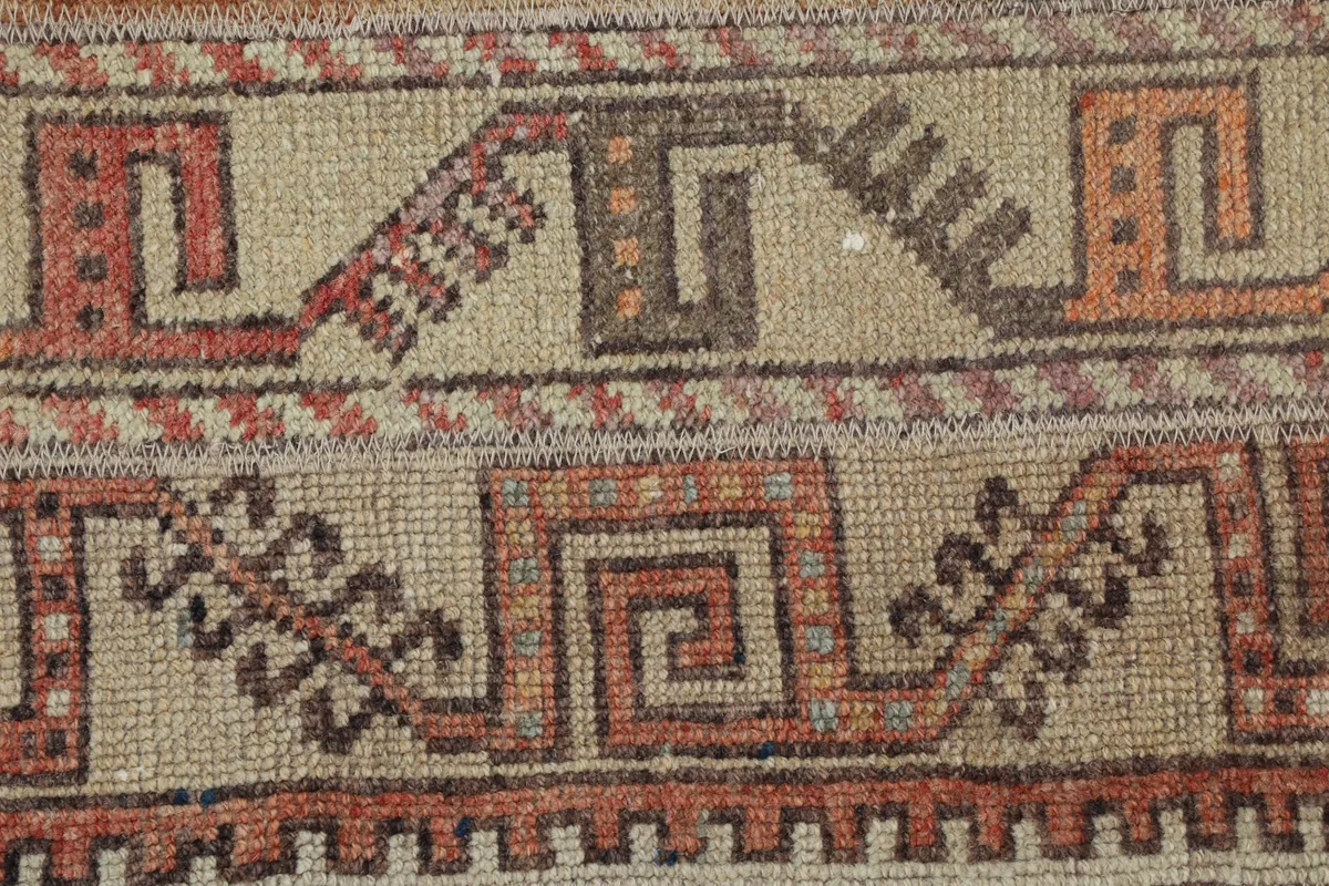Extreme close-up showing the low wool pile and hand-knotted weave of the rug