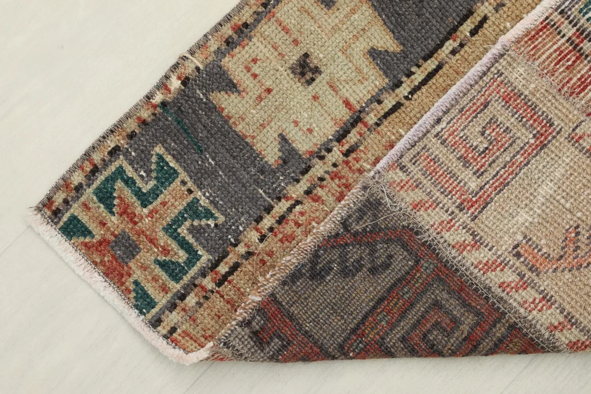 Corner of the rug folded back to show the cotton foundation and reverse side