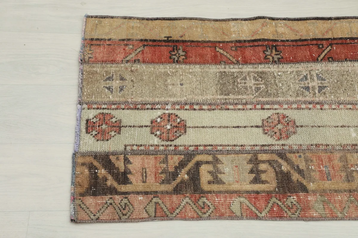 Detailed view of the rug's patterns, including tribal elements in rust, beige, and brown