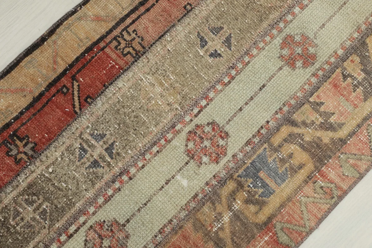 Diagonal close-up of the rug's patchwork sections, showing different textures and motifs