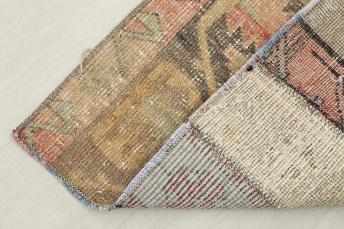 View of the rug's cotton foundation and the reverse side of the hand-knotted wool pile
