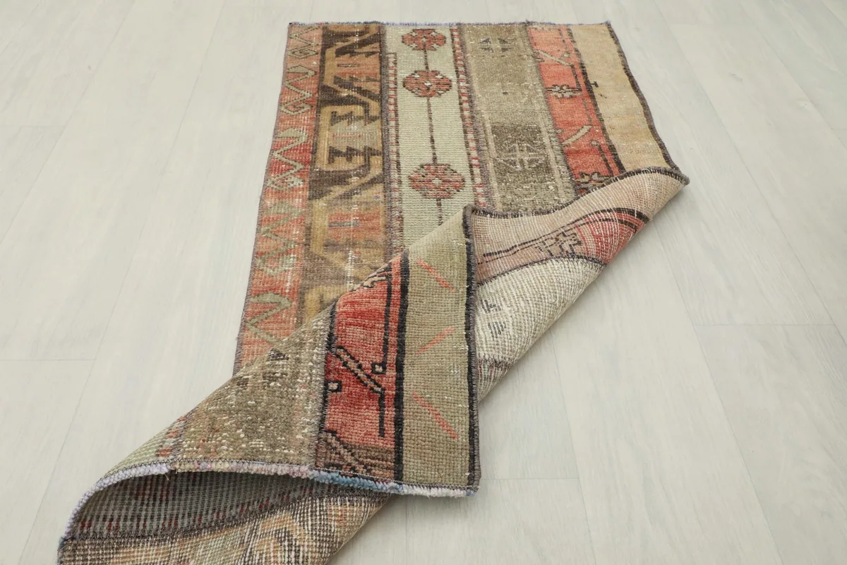 Rug partially folded, displaying both the front and back of the vintage Anatolian piece
