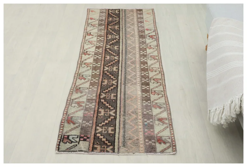 Full overhead view of a 2'0" x 5'7" vintage Anatolian runner with striped tribal patterns on a white background.