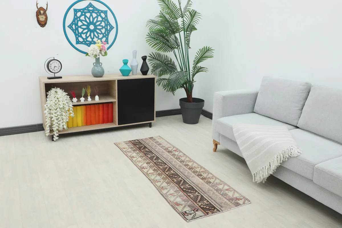 Vintage Anatolian runner rug displayed in a living room setting with a sofa and console table.