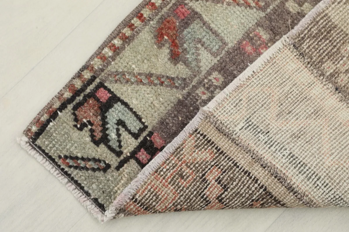 View of the back of the vintage runner, revealing the hand-knotted construction and cotton foundation.
