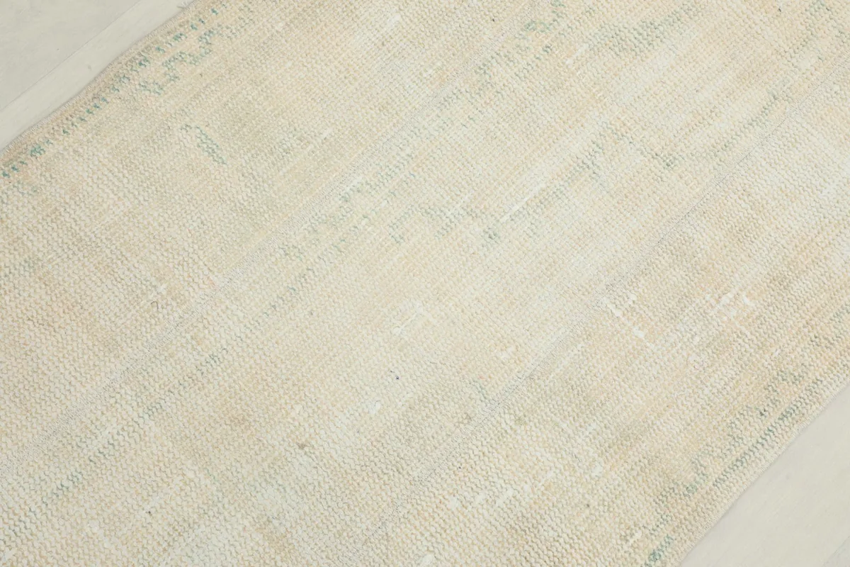 Close-up of the low wool pile, showing the hand-knotted texture and soft color variations.