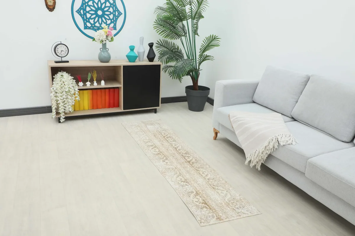 Vintage runner rug laid in a modern living room setting with a light sofa