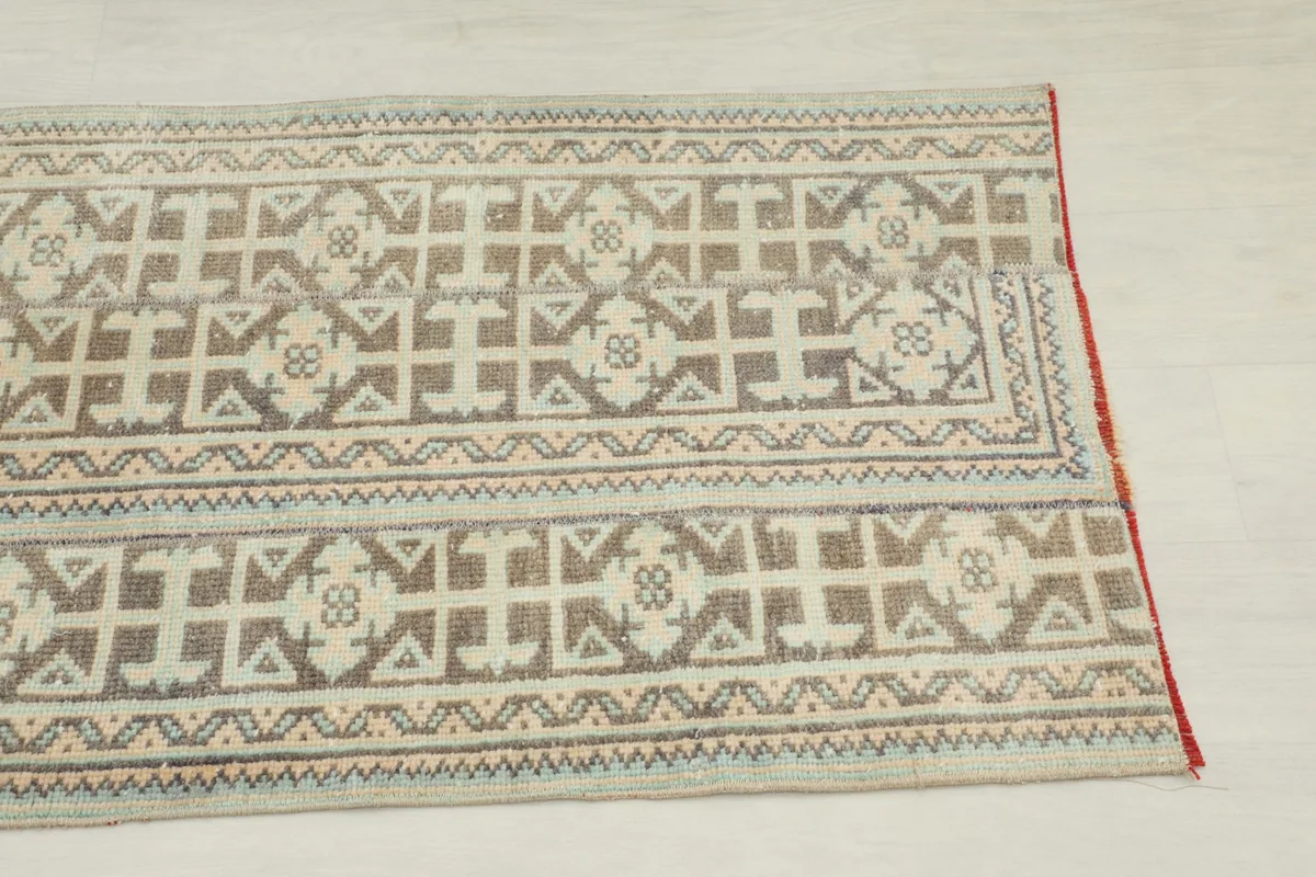 Close-up detail of the geometric patterns and colors on the vintage Anatolian rug