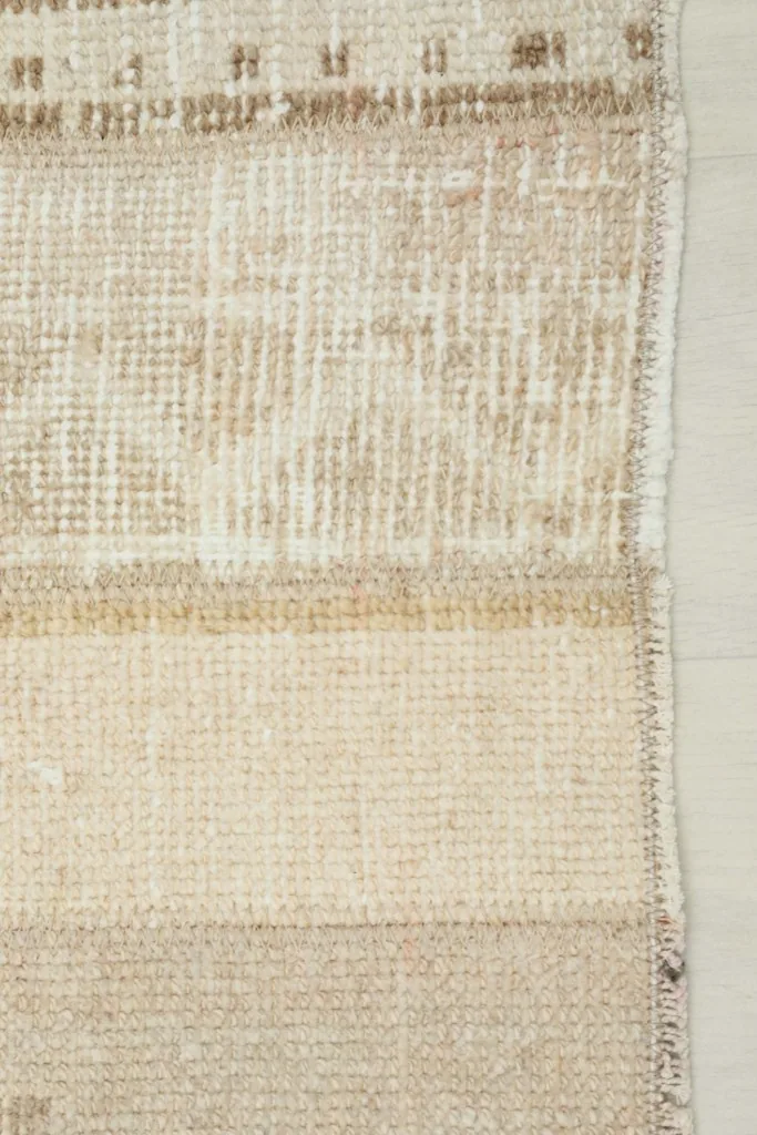 Close-up of the side edge and the transition between different patterned bands on the runner.
