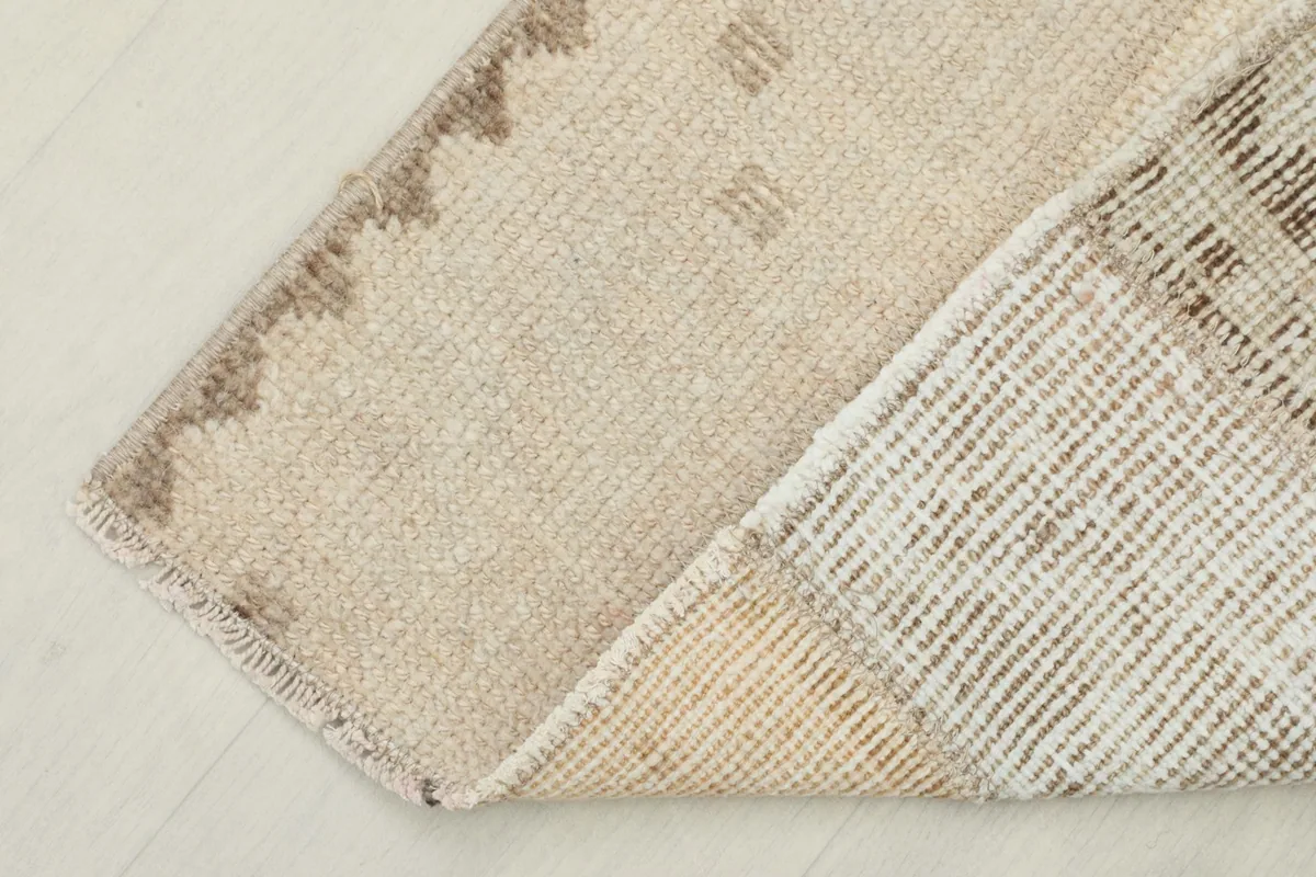 Corner view showing the reverse side (cotton foundation) and the hand-knotted construction of the rug.