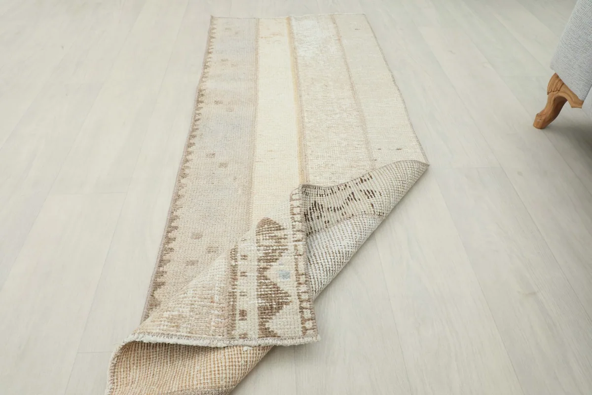 The runner partially folded, revealing the back construction and the overall flexibility of the vintage piece.