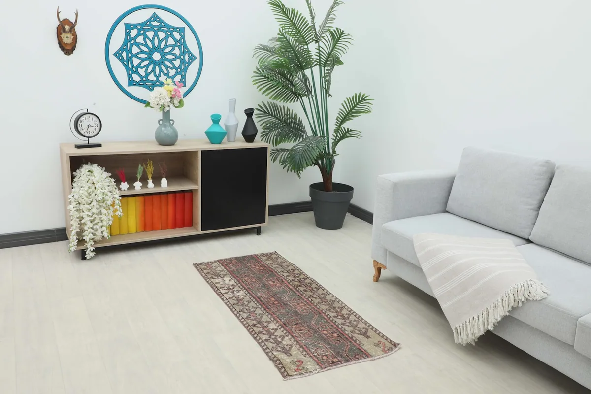 Vintage charcoal and beige rug placed in a living room setting next to a sofa