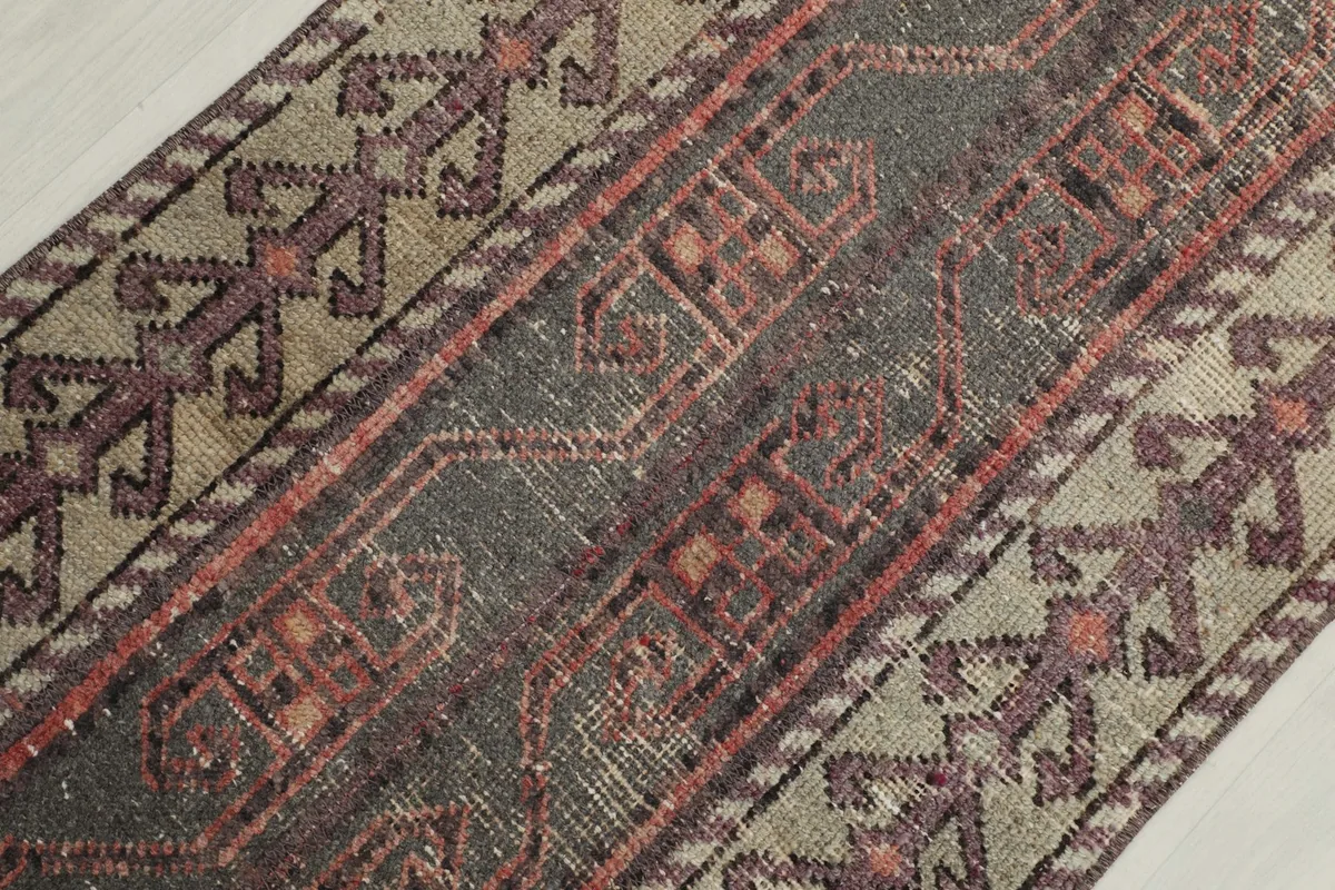 Close-up of the rug's surface, revealing the low pile and vintage wear