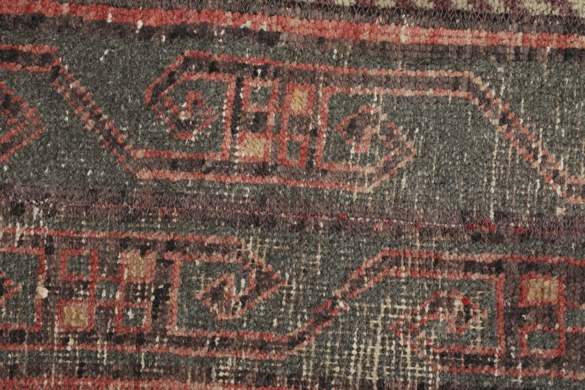 Detailed view of the low wool pile and the intricate knotting of the vintage rug