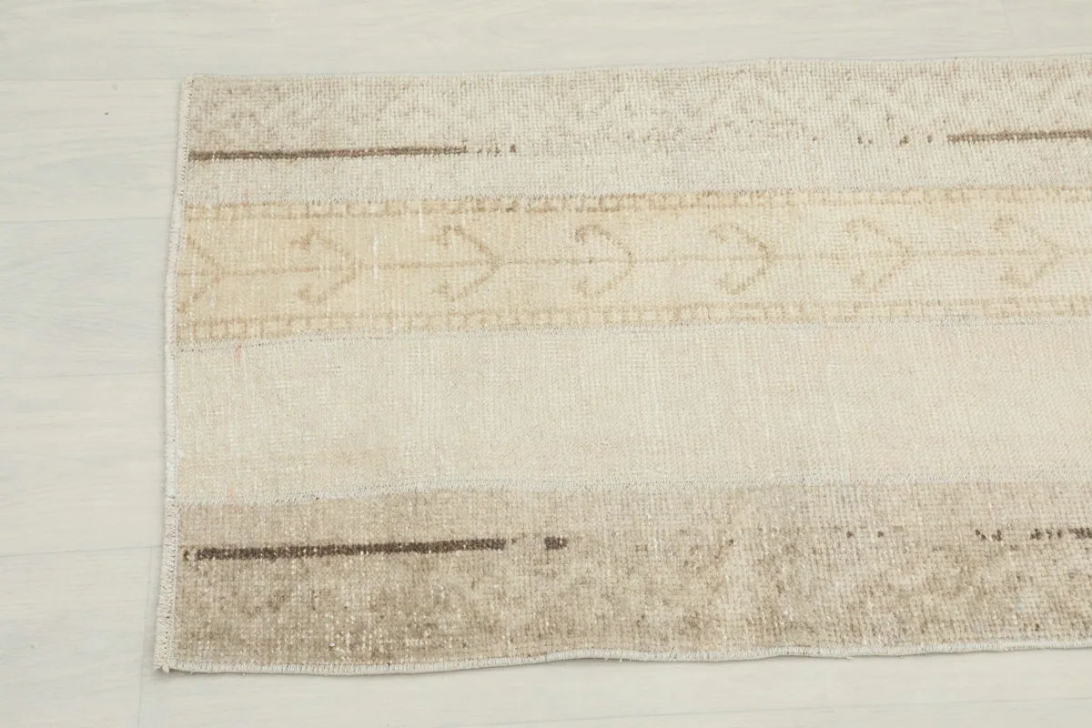 Close-up of the other end of the runner rug, displaying the natural wear and variations in the pile.