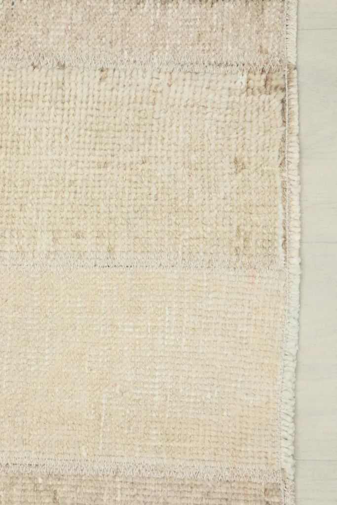 Close-up of a section of the rug, revealing the authentic patina and subtle color shifts in the cream field.