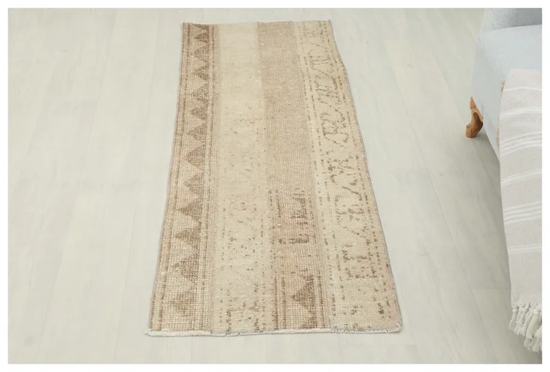 Full top view of the beige and tan striped vintage runner on a white floor