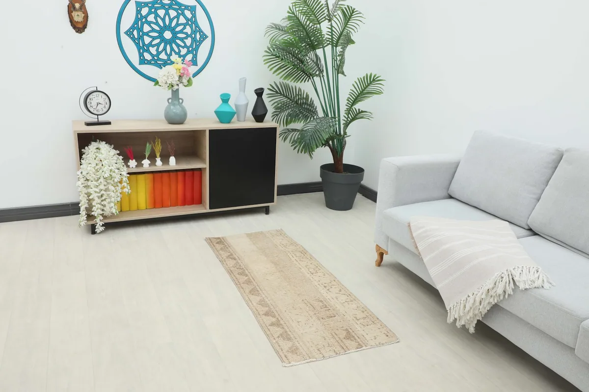 Runner placed in a living space with a light gray sofa and wooden cabinet