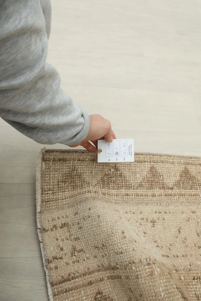 Hand holding a size tag near the runner, showing scale and detail