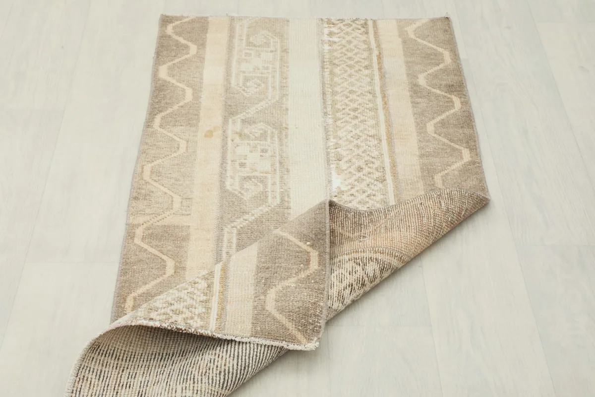 The rug partially folded, showing its flexibility and the reverse side.