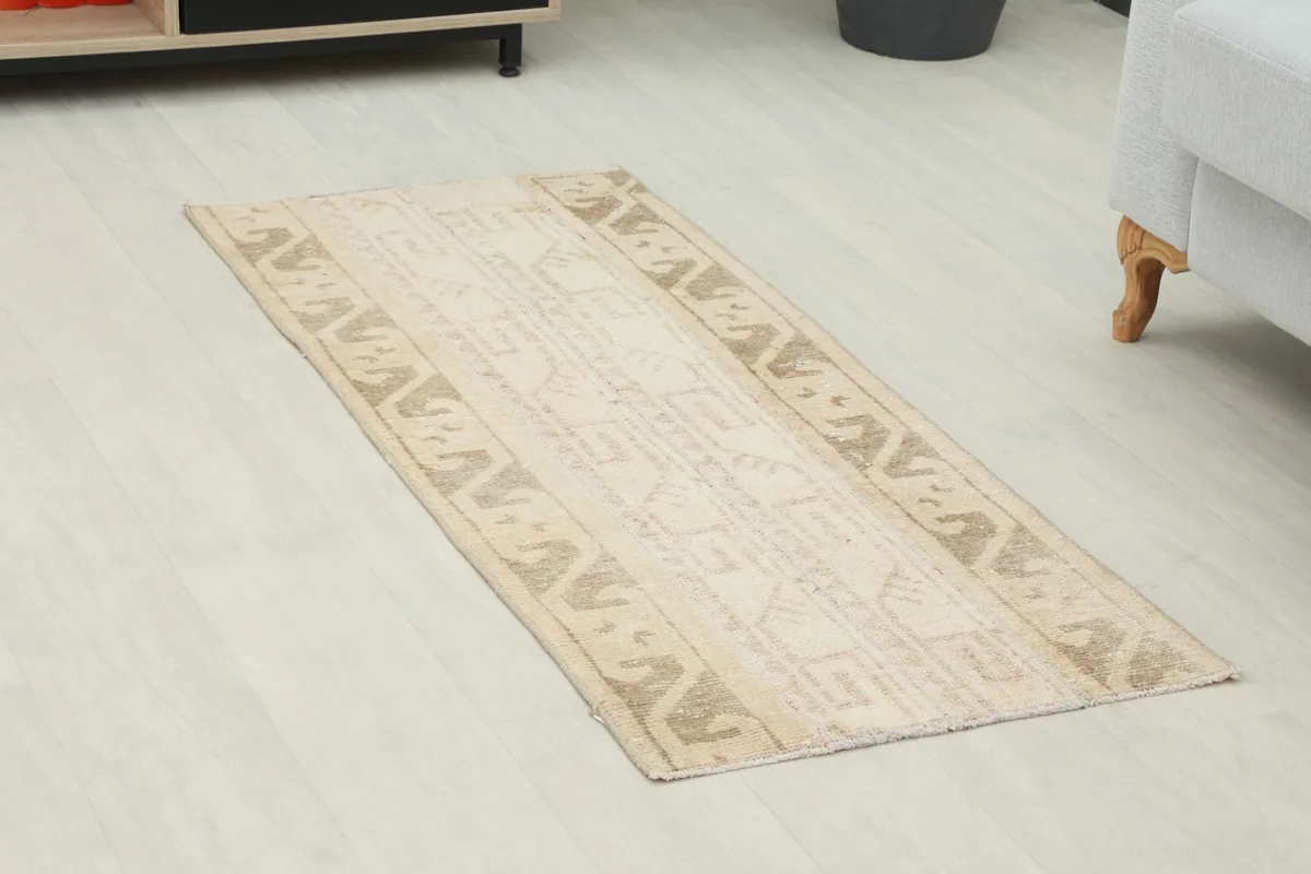 Angled view of the tan and brown geometric rug, showing its placement in a room.