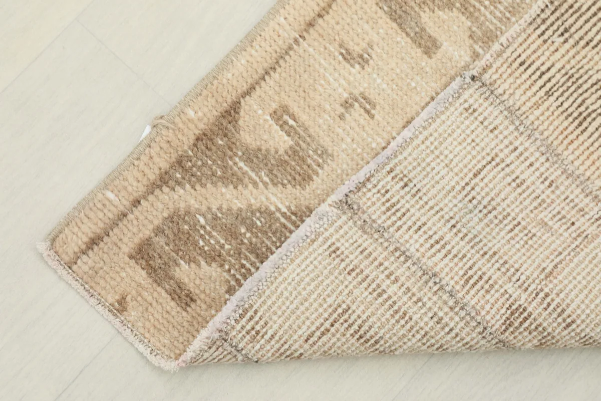 View of the back of the rug, revealing the tightly woven cotton foundation and knots.