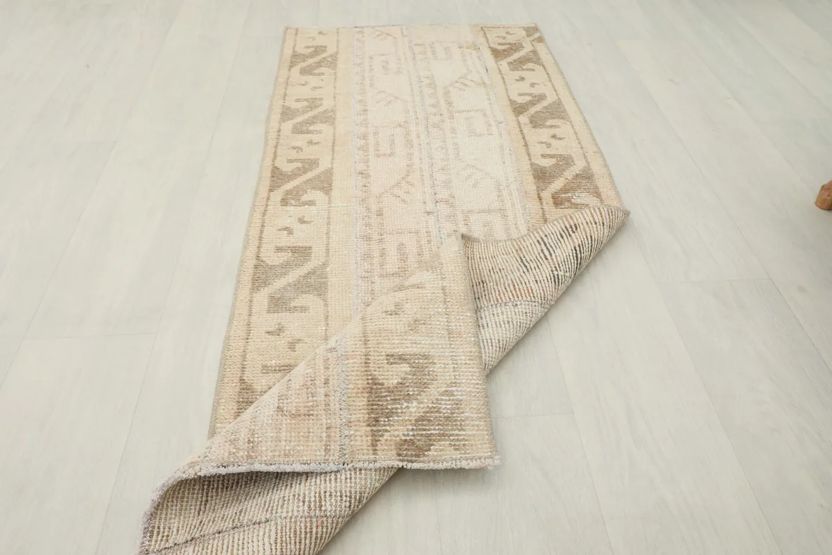 Rug partially folded, showcasing its flexibility and construction from an elevated angle.