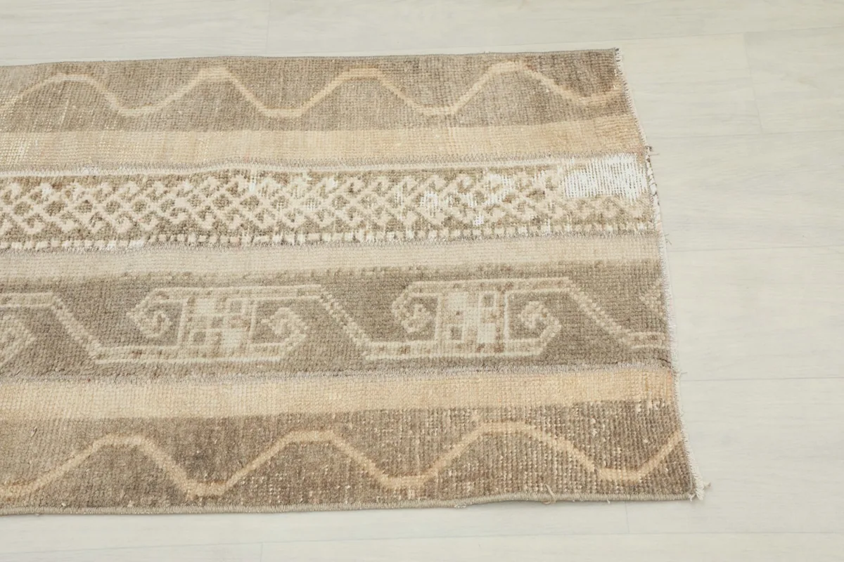 Close-up detail of the tribal and geometric patterns in the rug's beige and brown stripes