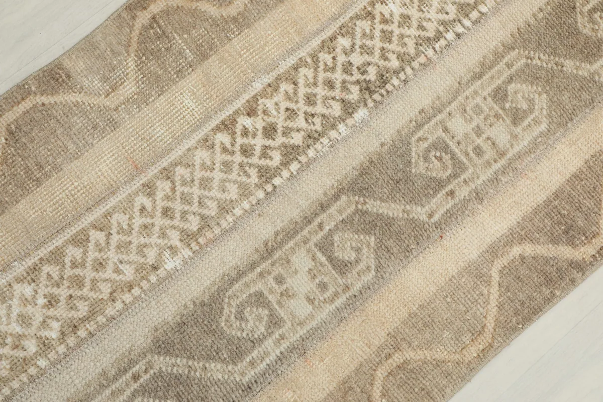 Diagonal close-up showing the texture and intricate motifs of the wool pile