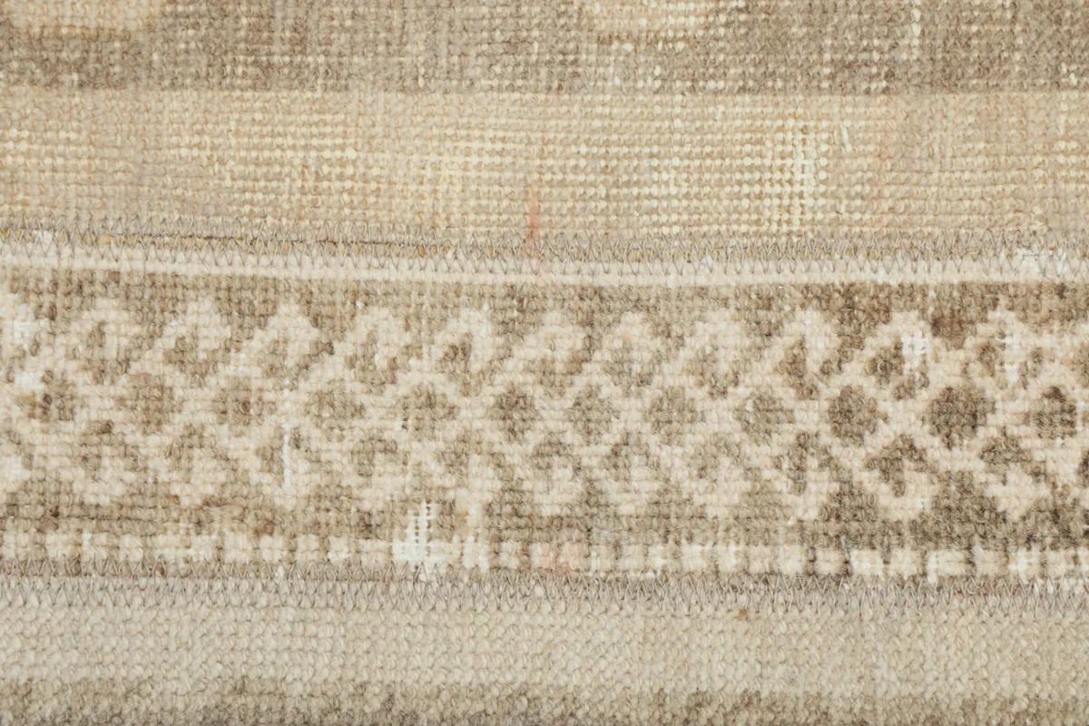 Extreme close-up of a specific geometric pattern band in beige and brown