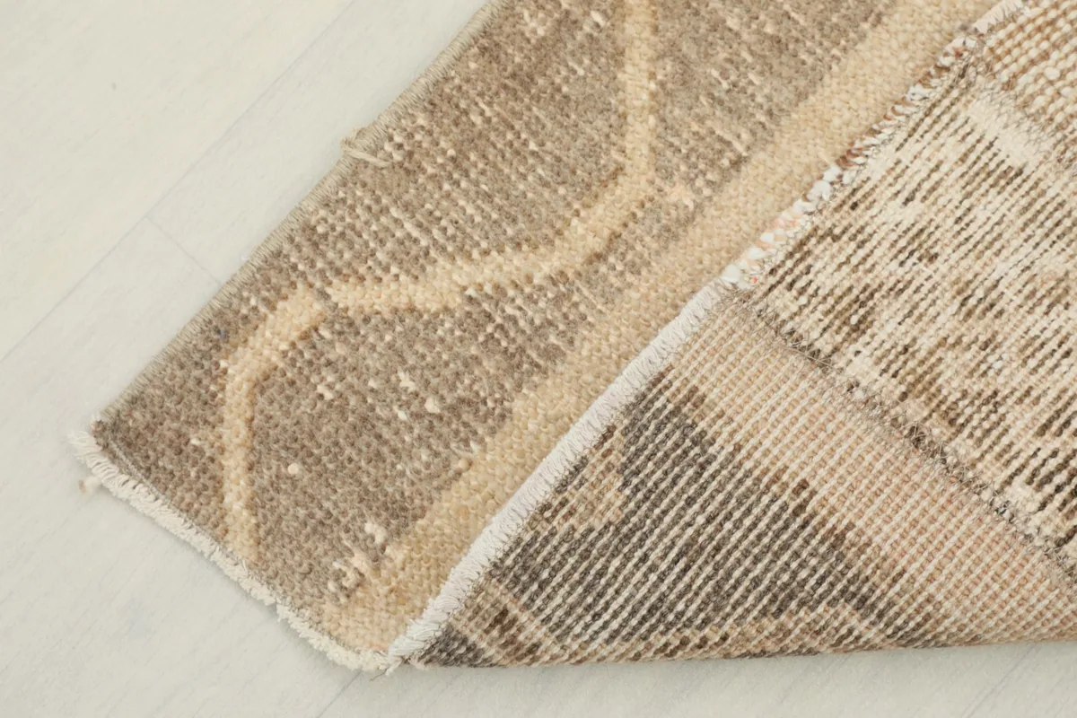 View of the back of the rug, showing the cotton foundation and hand-knotting