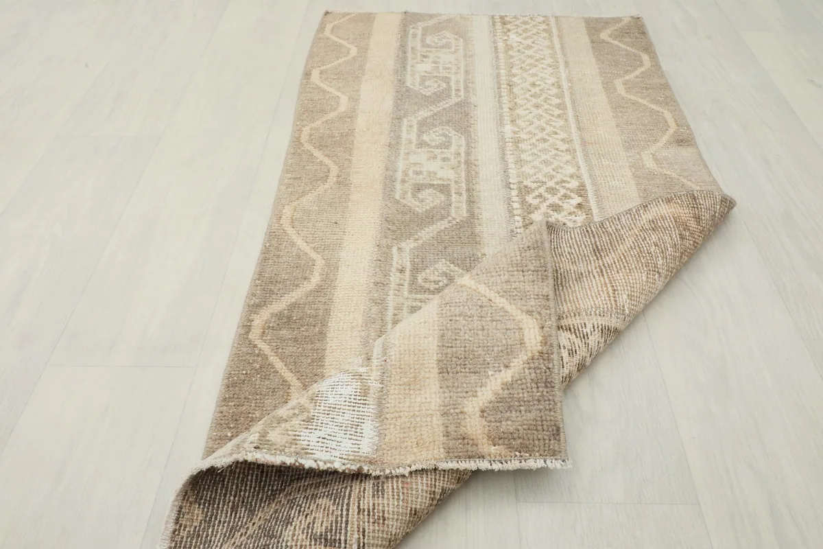 Rug partially folded, displaying the flexibility and back of the vintage piece