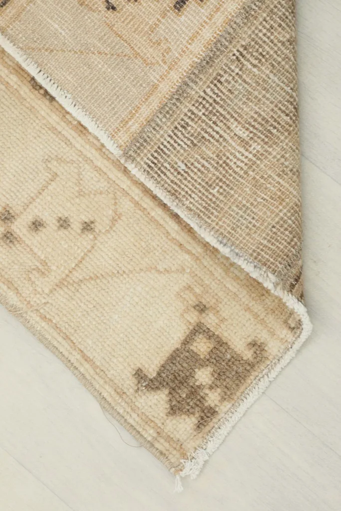 View of the back of the rug, revealing the cotton foundation and the hand-knotted construction.