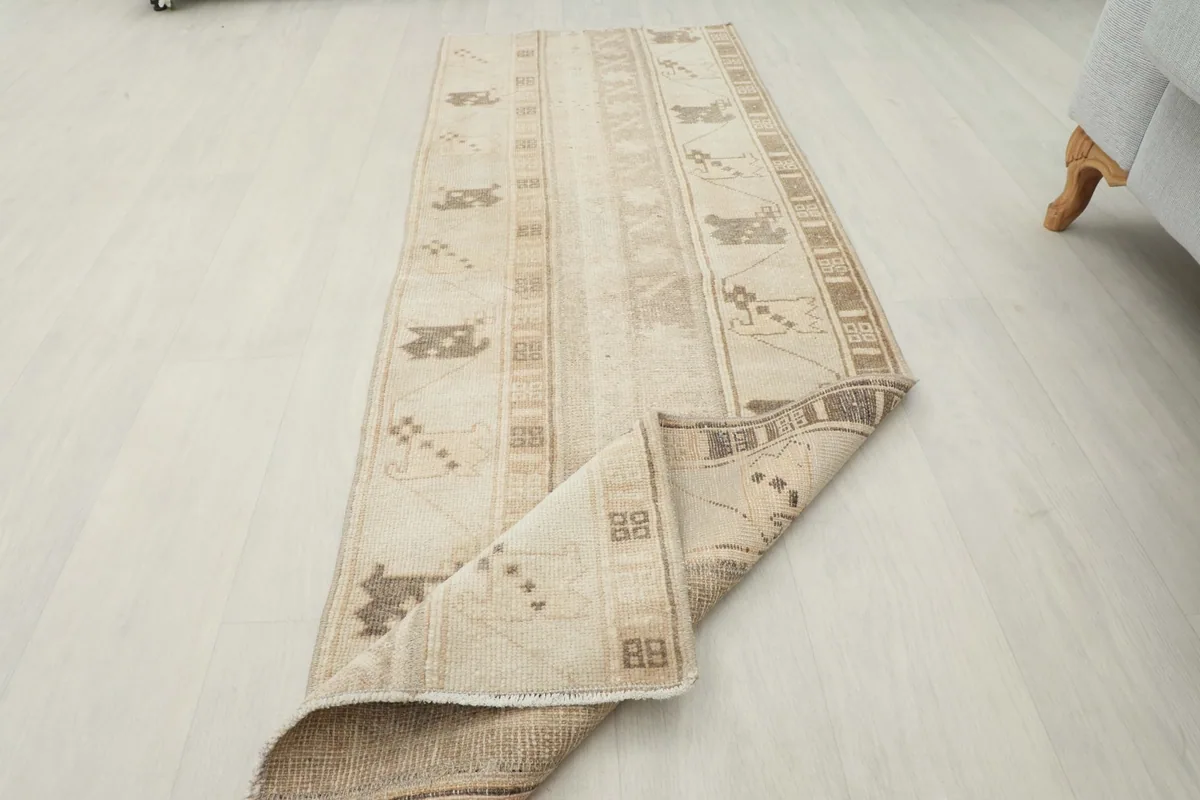 The runner partially folded, showing the flexibility and thickness of the vintage wool rug.