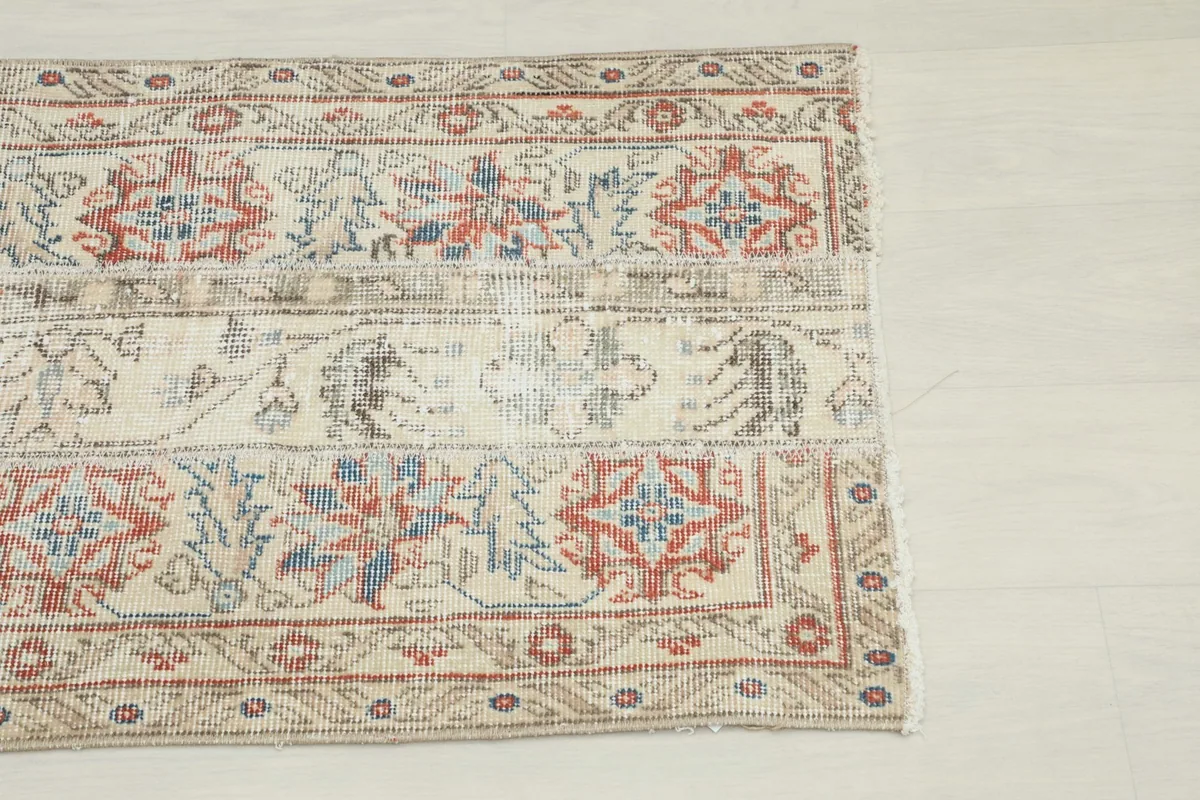 Close-up of the upper right section of the rug, showing red and blue patterns and border