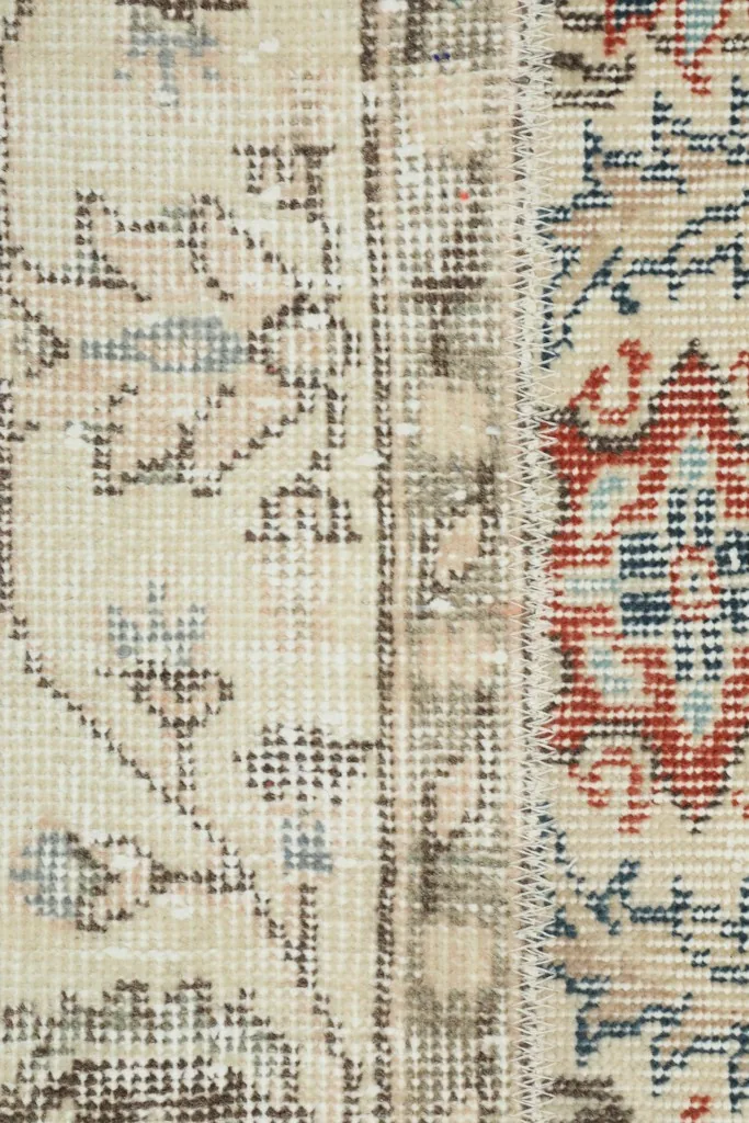 Extreme close-up of the beige field with blue and brown stylized patterns