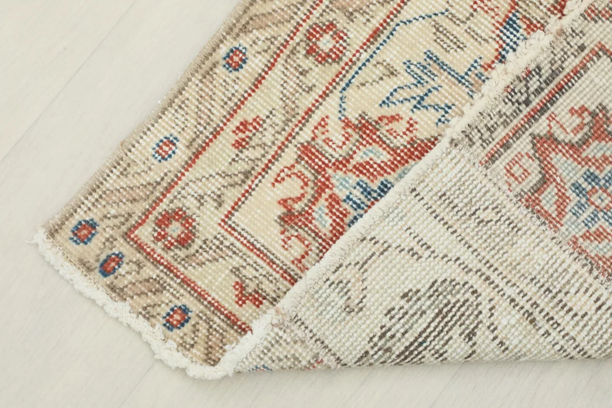View of the rug's back and folded corner, revealing the cotton foundation