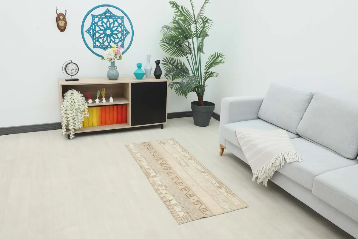 Vintage runner rug in a room setting, placed in front of a modern sofa and console table.