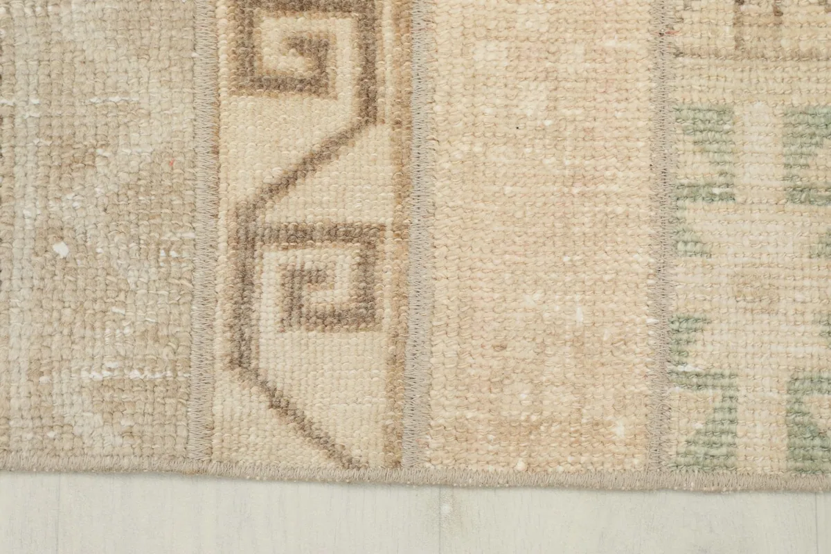 Close-up showing the texture of the low wool pile and the distinct color blocks within the rug.